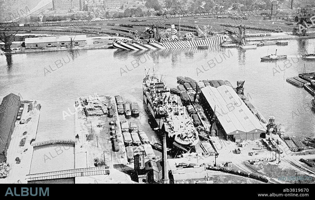 A ship with dazzle camouflage at the Alexandra Dock, Hull, England, during the First World War. Dazzle camouflage, also known as razzle dazzle or dazzle painting, was a family of ship camouflage used extensively in World War I and to a lesser extent in World War II and afterwards. Credited to artist Norman Wilkinson, though with a prior claim by the zoologist John Graham Kerr, it consisted of complex patterns of geometric shapes in contrasting colors, interrupting and intersecting each other. Unlike some other forms of camouflage, dazzle works not by offering concealment but by making it difficult to estimate a target's range, speed and heading.