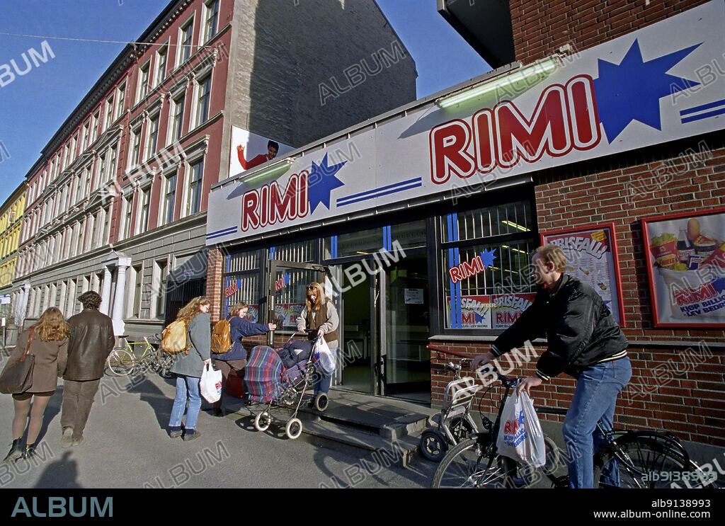 Oslo 1995-03-21: Grocery store Rimi at St. Hanshaugen, at the intersection Waldemar Thranes gate / Ullevålsveien, March 21, 1995. Young man with rimi plastic bag on bicycle. Young woman with stroller on the way down the stairs. Students with leather transfers. Young couple strolling on the sidewalk at Rosa Bygård. Photo: Bjørn-Owe Holmberg / NTB / NTB.
