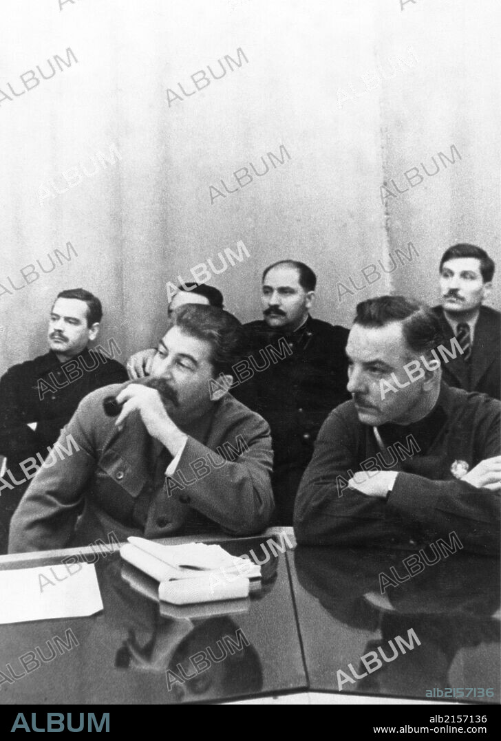 Joseph stalin (front, left) sits with k, e, voroshilov at a conference of best combine workers and soviet government, left to right, back: a, a, andreyev, l, m, kaganovich, v, j, chubar, ussr, 1930s.
