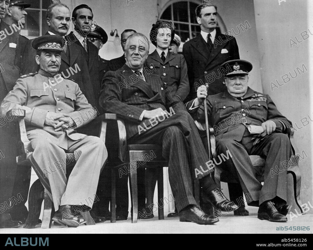 Marshall Stalin Gravely Ill - A picture taken during the Teheran Conference in December 1943m showing (left to right) Marshall Stalin, President Roosevelt and Mr. Churchill.It has been reported that Marshal Stalin is gravely ill, suffering from a haemorrhage of the brain, loss of speech and paralysis of the right arm and leg. Moscow radio announce that the seizure occurred on Sunday night and that the 73-years-old Marshal has failed to respond to the treatment of nine doctors. The Big Three at Teheran. Molotov and Hopkins stand behind Stalin and Churchill's daughter and Eden stand behind Roosevelt and Churchill. March 4, 1953. (Photo by Fox Photos).