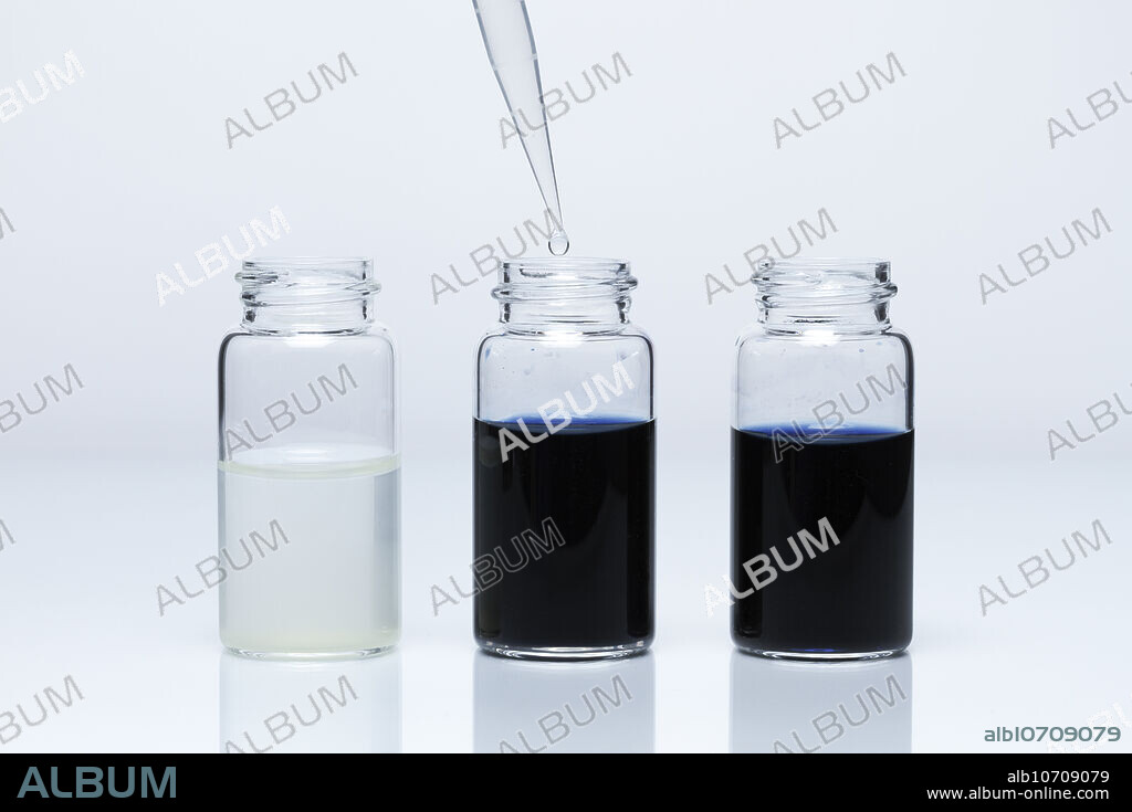 Iodine reduction by tin, 1 of 3. Tin(II) sulphate (SnSO4) solution has pale yellow colour (left vial). Iodine (I2) dissolved in water with added potassium iodide (KI) and polyvinyl alcohol has deep blue colour (right vial). When tin(II) sulphate solution is added drop by drop to the iodine solution (middle vial), it becomes colorless, as I2 is reduced to I- and Sn2+ is oxidized to Sn4+: Sn2+ + I2 -> Sn4+ + I-.