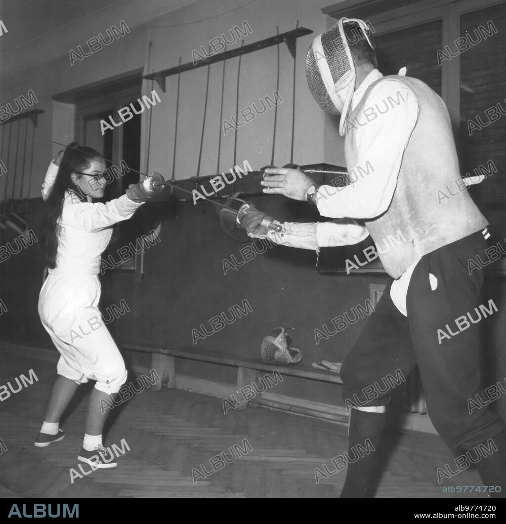 February 19, 1963. The teacher teaches a student how to use the Foil. The Weapons Rooms today have a different Spirit with the presence of Women, who find in this sport movements that give elasticity to their figure.