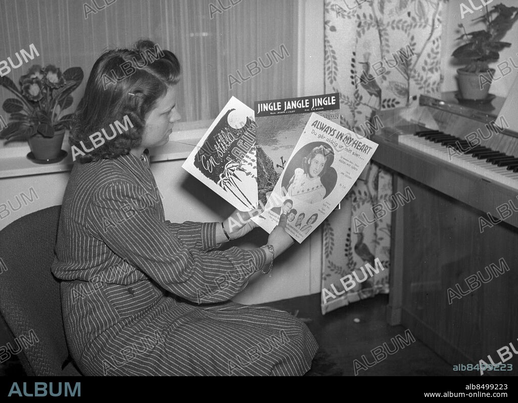 Göteborg 1943-05-28 - Ung kvinna sitter med pianonoter vid ett piano - noterna är Jingle Jangle Jingle, Always in my Heart och En stilla Lagun *** Local Caption *** GT Låda Krep 2012-01 . KAMERAREPORTAGE.