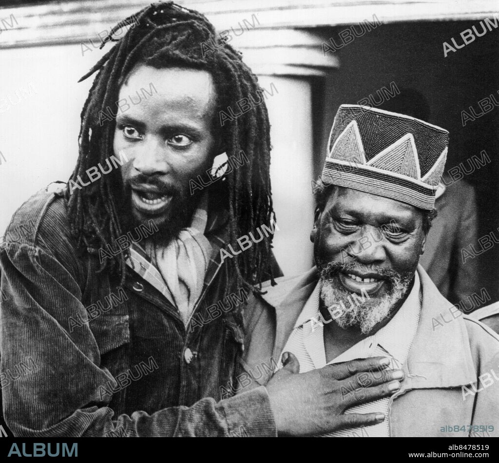 Orig. bildtext... MAU-MAU LEADERS COME OUT OF HIDING AND PLEDGE ALLEGIANCE TO NEW STATE Assured of amnesty by Prime Minister Jomo Kenyatta, many members of the outlawed Mau-Mau terrorists of Kenya, including the leaders, have come forward. The leaders have reported to the Premier and have promised to work under him. It is estimated that som 6 500 Mau-Mau have come out of their hiding in the forest and jungles. Photo shows: The self-styled Field Marshal Wariama, supreme Mau-Mau-leader (left) called at the home of Premier Kenyatta at Gatundu, near Nairobi, to pledge his support. He is saying here Kenyatta - he is my father. Anm. J Kenyatta, 1891-1978, kenyansk frihetskämpe och politiker, premiärminister 1963-1964, president från 1964. Ledare för Mau-Mau-rörelsen. Mau-Mau-rörelsen - gerillarörelse i Kenya 1952-1956 inom folkgruppen kikuyu, som kämpade för afrikanernas rätt till jorden. På 1950-talet började en gerillarörelse växa fram i den brittiska kolonin Kenya. Britterna införde undantagstillstånd 1952 och under några år framåt fördes ett krig mellan kolonialmakten och Mau-mau-rörelsen. Under upproret fängslades Kenyatta och all politisk aktivitet förbjöds fram till 1955. Undantagstillståndet upphörde i januari 1960. 12 december 1963 blev Kenya självständigt. Rastafari Rastaflätor Dreadlocks CD85 persons: JOMO KENYATTA sites: KENYA;AFRIKA.