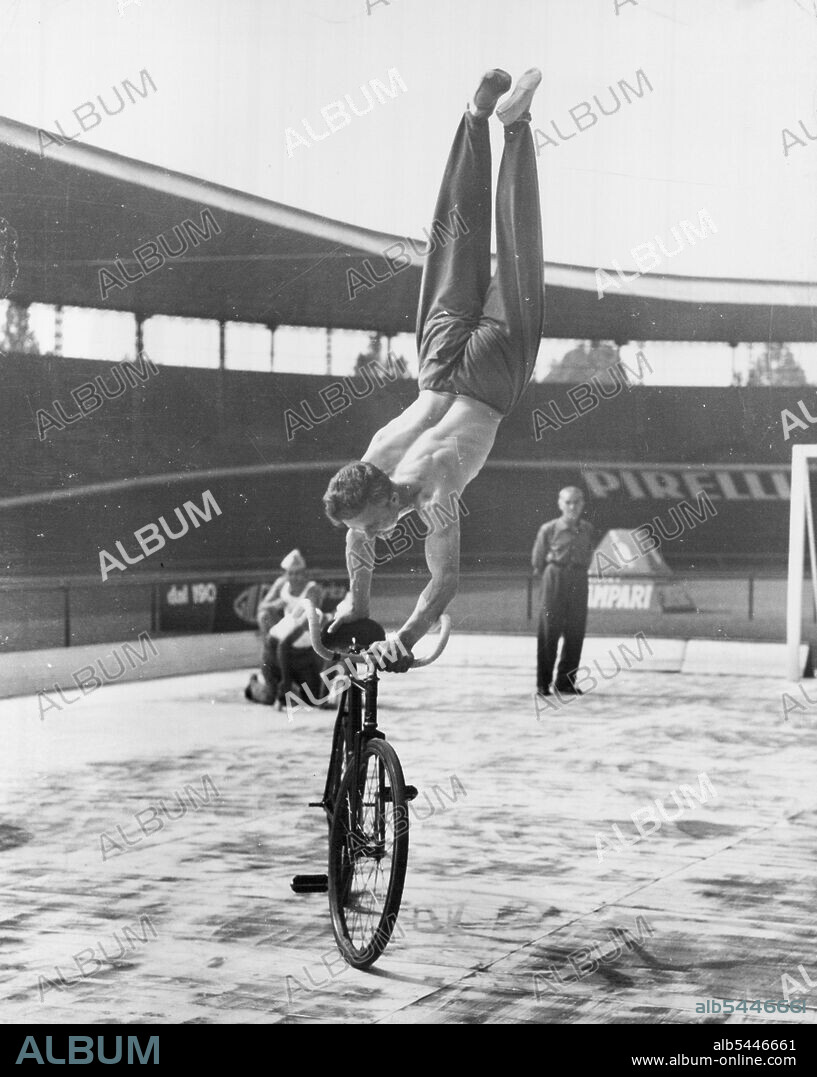 Going Around In Cycles - "Look, MA, No Feet!" Yugoslav cyclist Stanislav Vakulic does a variation of the no hands routine during the recent world cycling championships held near Rome. He works up a good pace and then stands on the handlebars and saddle on his hands. September 23, 1955. (Photo by United Press).