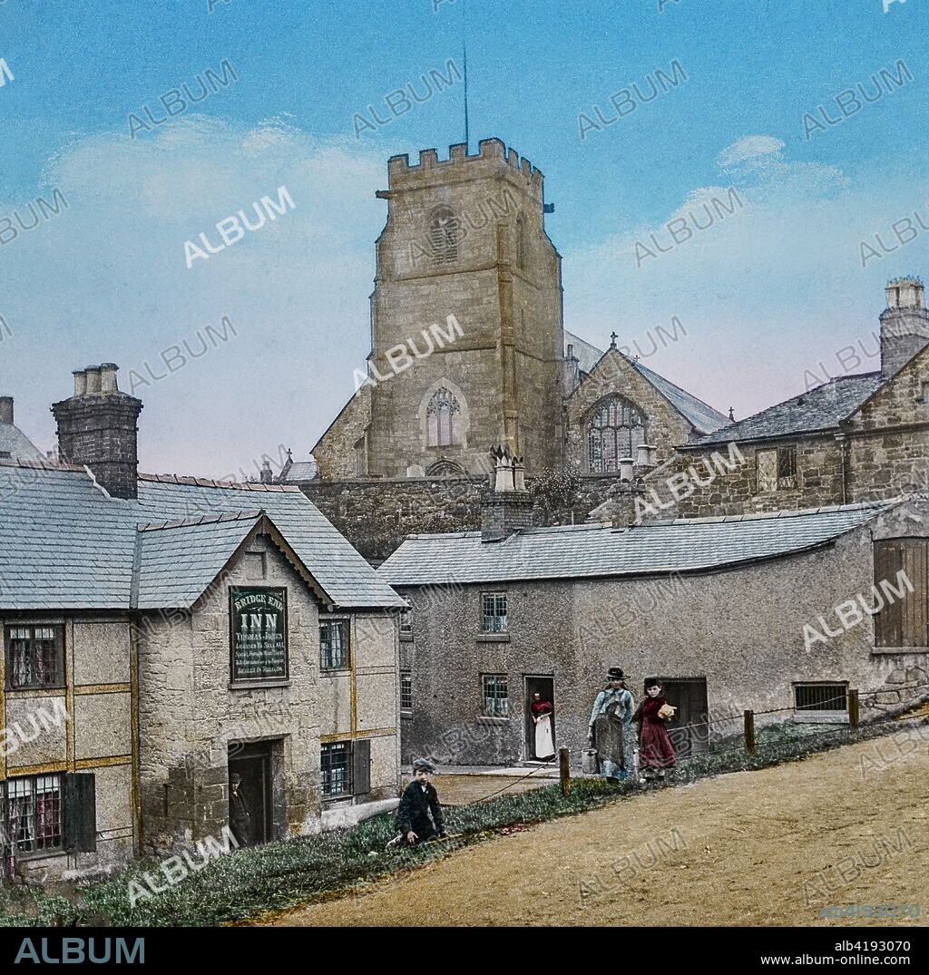 Magic Lantern slide circa 1900 hand coloured. The Bridge End Inn in Ruabon (Welsh: Rhiwabon pronounced [r??????b?n]) A village and community in the county borough of Wrexham in Wales. The name 'Rhiwabon' comes from 'Rhiw Fabon', 'Rhiw' being the Welsh word for 'hill' and 'Fabon' being a mutation from St Mabon, the original church name, of earlier, Celtic origin (see Mabon).' An older English spelling, Rhuabon, can sometimes be seen. In the image are people outside the public house with the church in the background.