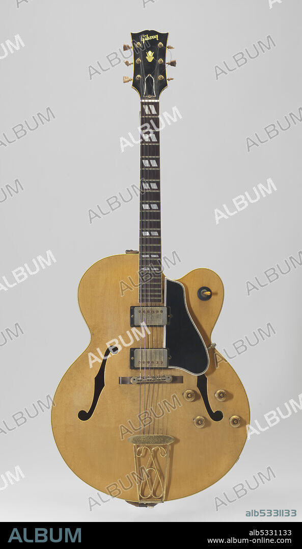 A Gibson ES-350T semi-acoustic guitar named Maybellene. The wood is light, and the tuning keys are damaged. A black and orange label with the serial number (A33643) and where the guitar was made (Kalamazoo, MI) can be seen through one of the F-holes. The case is treated canvas on wood with velvet lining. Chuck Berry (1926-2017) was an African-American singer, songwriter and guitarist, and one of the pioneers of rock and roll music.