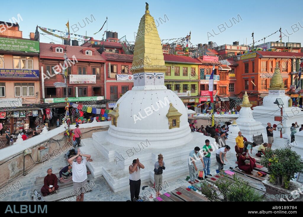 Nepal: Buddhists praying in the Bodhnath (Baudha) complex in Kathmandu. Set squarely in the siddhi, a zone of supernatural power where guardian deities dwell and wishes are granted, Bodhnath is located just east of Kathmandu, along the old trade road to Lhasa. Known to the Tibetans simply as Chorten Chempo, or 'Great Stupa', it has been the Mecca of Tibetans in exile ever since the Chinese occupation of their homeland in 1950. Bodhnath has also developed as a centre for the study of Tibetan Buddhism.