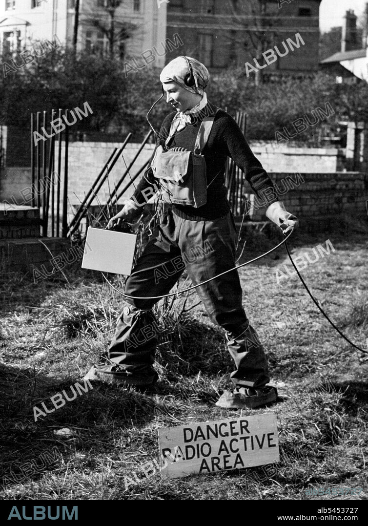 Britain's Women Learn Atom Defence -- Wearing anti-gas boots and headphones, Pamela Preston of the KVS probes and area with a Geiger monitor for supposed deadly radioactivity.A three-girl team drawn from the Red cross, the Women's voluntary service and the red cross took part in a demonstration of atomic defence techniques at Winchester. England, Feb 18, The display was given by naval personnel from the Atomic defense school, HMS Phoenix, and was organized by the Hampshire civil defense corps. August 01, 1952. (Photo by Associated Press Photo).