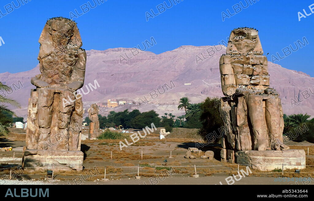 The Colossi of Memnon; are two massive stone statues of the Pharaoh Amenhotep III, who reigned in Egypt during the Dynasty XVIII. Since 1350 BC, they have stood in the Theban Necropolis, located west of the River Nile from the modern city of Luxor. the Mortuary Temple of Amenhotep III, also known as Kom el-Hettân,  built by the architect Amenhotep, son of Habu, for the Pharaoh Amenhotep III (or Amenhetep III) during the 18th Dynasty in the New Kingdom..
