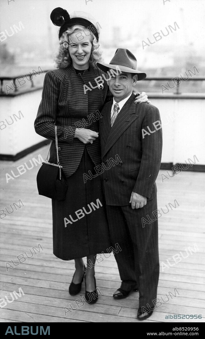 Orig. bildtext... AMERICA'S CHAMPION JOCKEY ARRIVES WOULD LIKE TO RIDE AGAINST GORDON Johnny Longden, son of a Yorkshire coalminer and now champion jockey of the United States, arrived at Southampton with his wife to-day (Thursday) in the Cunard White Star liner Queen Elizabeth for a 30-day tour of England, Ireland and France. Longden, who is 39, was born in Wakefield (Yorkshire) and taken to Canada by his parents when he was two years of age. He started riding in 1927 and he won nearly 3,500 races. His earnings have been estimated at £1,750,000. Longden said on arrival at Southampton that he had brought his racing gear and would like to ride against Gordon Richards. Picture shows: Johnny Longden and his wife, Hazel, at Southampton to-day. Anm. Jockeys Jämförelser Kortväxta persons: Hazel Longden ;Johnny Longden sites: SOUTHAMPTON ;STORBRITANNIEN ;USA*.