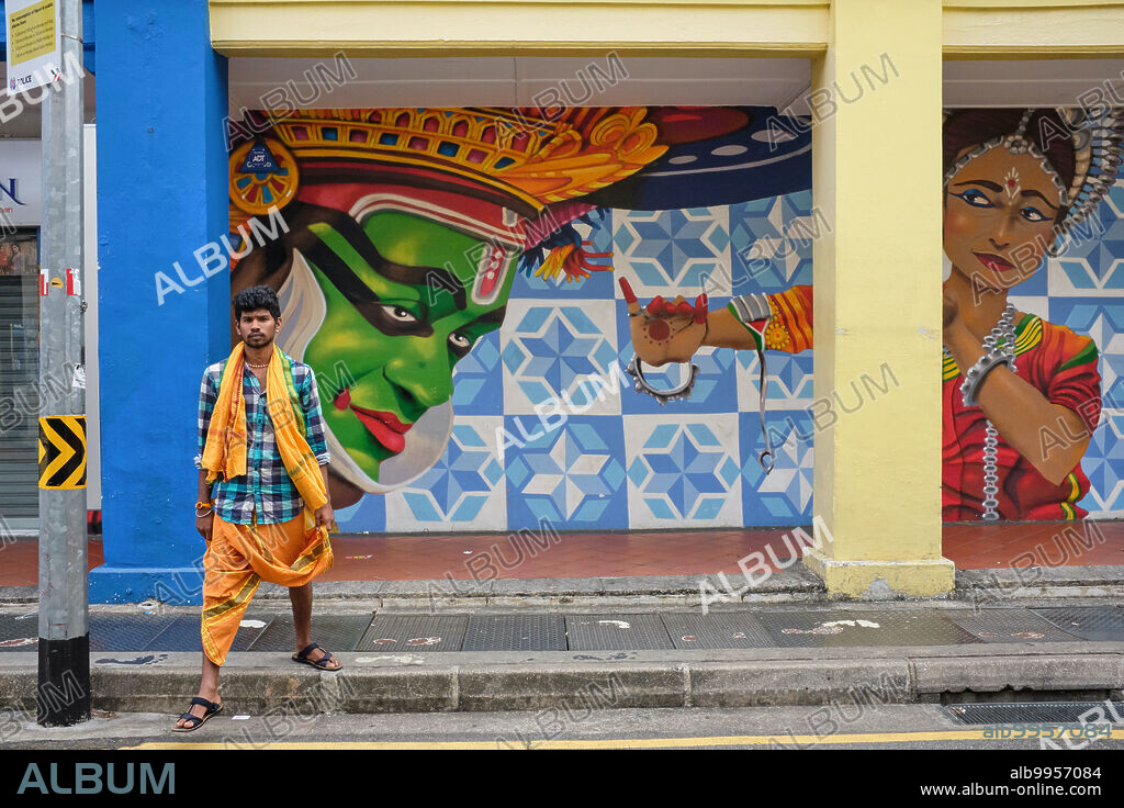 Singapore: A South Indian man in traditional clothing in front of a mural by Didier Mathieu aka Jaba in Upper Dickson Road, Little India, depicting South Indian Kathaka dancers.