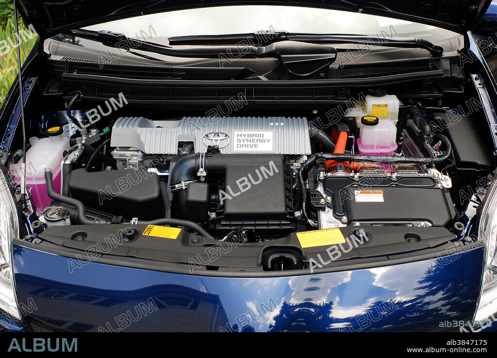 Engine compartment of a Generation III Toyota Prius Hybrid, showing hybrid drive components. Hybrid cars utilize a battery to store energy generated by braking and coasting and use it to drive an electric motor in tandem with a small gasoline engine. Together they provide power to drive the car, while using less gasoline than an internal combustion engine alone.