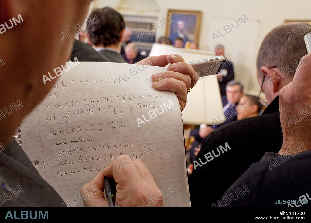 A reporter takes notes while President  Barack Obama and Prime Minister Gordon Brown of the United Kingdom speak to the press in the  Oval Office 3/3/09. .