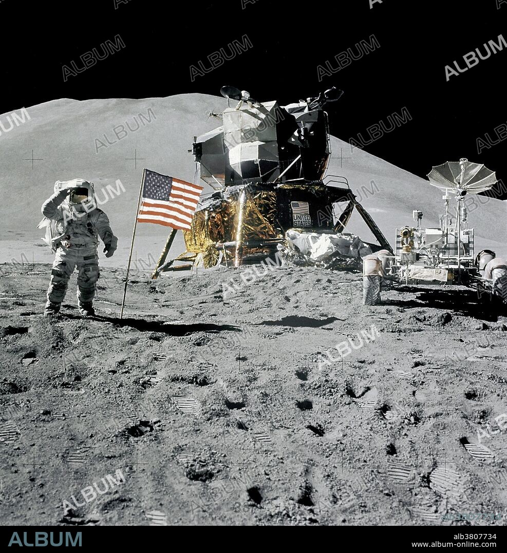 Astronaut James B. Irwin, lunar module pilot, gives a military salute while standing beside the deployed United States flag during the Apollo 15 lunar surface extravehicular activity (EVA) at the Hadley-Apennine landing site on August 1, 1971. The flag was deployed toward the end of EVA-2. The Lunar Module (LM) "Falcon" is in the center. On the right is the Lunar Roving Vehicle (LRV). This view is looking almost due south. Hadley Delta in the background rises approximately 4,000 meters (about 13,124 feet) above the plain. The base of the mountain is approximately 5 kilometers (about 3 statute miles) away. This photograph was taken by astronaut David R. Scott, Apollo 15 commander. While astronauts Scott and Irwin descended in the LM to explore the moon, astronaut Alfred M. Worden, command module pilot, remained with the Command and Service Modules (CSM) in lunar orbit.