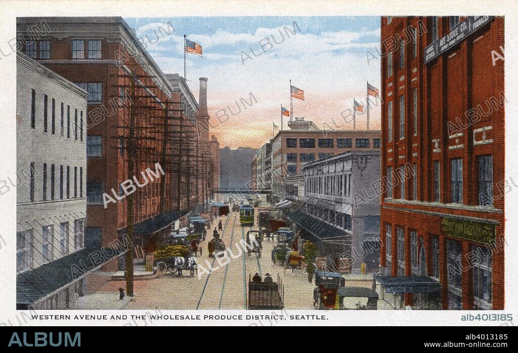 Western Avenue and the wholesale produce district, Seattle, Washington, USA, 1911. Vintage postcard showing the wholesale produce district on Western Avenue, the stalls open on to the street where a streetcar travels along the rails. Horse-drawn wagons line the street.