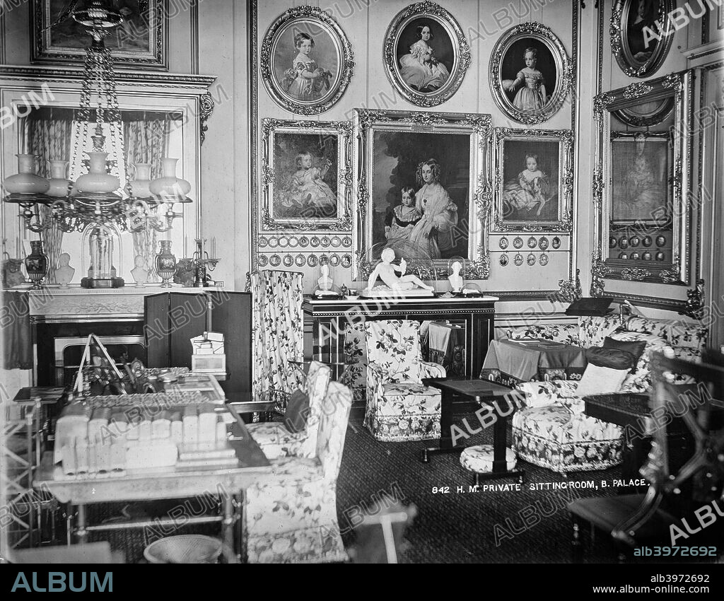 Queen Victoria's private sitting room, Buckingham Palace, London, c1870-c1900. The interior of Queen Victoria's private sitting room at Buckingham Palace. The wall is covered with paintings of her family.