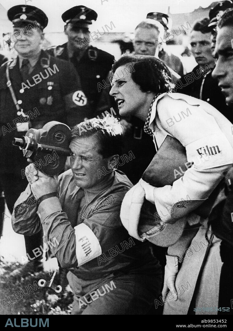 Cameraman Sepp Allgeier and Leni Riefenstahl during the shooting of the film Triumph of the Will in Nuremberg. Behind them SS members. [automated translation].
