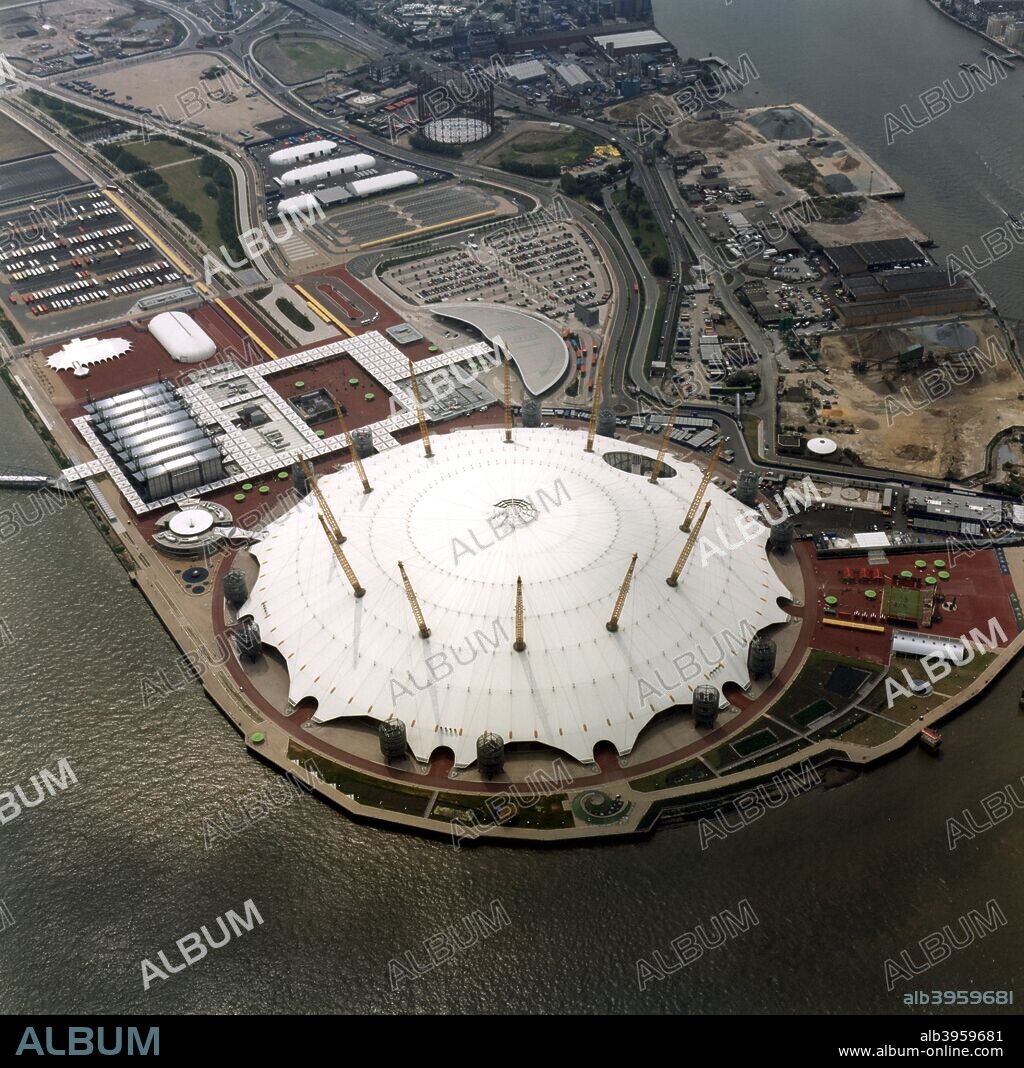 An aerial view of the Millennium Dome, Greenwich, London, 2000. The Millennium Dome, on a former gasworks site next to the River Thames in Greenwich, was erected in 1997-9 to house a visitor attraction for the Millennium. It is a huge structure with a circumference of 1 km and a height of 50m. Its remarkable design is based on a net of cables with a fabric covering.