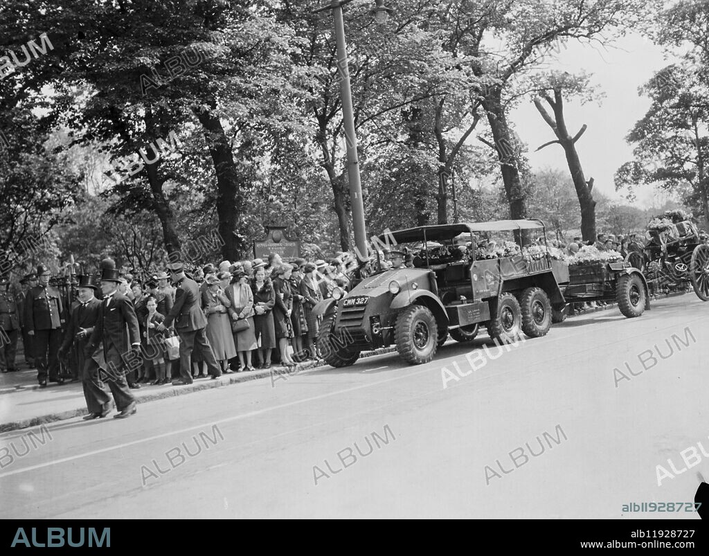 A military funeral procession in Woolwich , London . An armored vehicle tows a gun carriage onto which the coffin is placed . 23 May 1939.