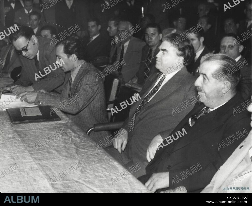 At Labor Congress -- While representatives of John L. Lewis Negotiated Sept. 7. In Detroit with Homer Martin, Embattled UAW President, to restore inter-union peace, the CWO Chairman was kept busy attending sessions of the Latin-American Labor Congress at Mexico City. He is shown between Gonzales Pena, Secretary of the General Union of workers in Loyalist Spain, And Leon Jouhaux, Secretary of France's General Confederation of Labor, at a session Sept 5. July 09, 1938. (Photo by Associated Press Photo).