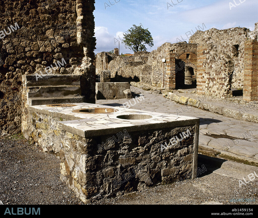 ARTE ROMANO. ITALIA. "TERMOPOLIO" o taberna especializada en la venta de bebidas calientes, ubicada en la Via Consolare. En la fotografía se aprecian las barras de piedra con huecos donde se colocaban las ánforas con la escancia de las bebidas. POMPEYA. La Campania.