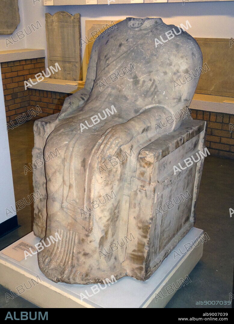 Seated male figure wearing a decorated sleeved chiton and himation marble. Greek. Dated 525 BC.