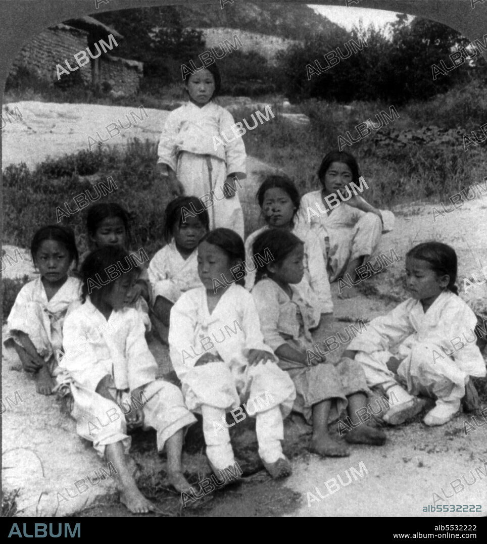 Photograph showing Joseon era boys from a poor area wearing torn clothes. Seoul, Korea 1900.
