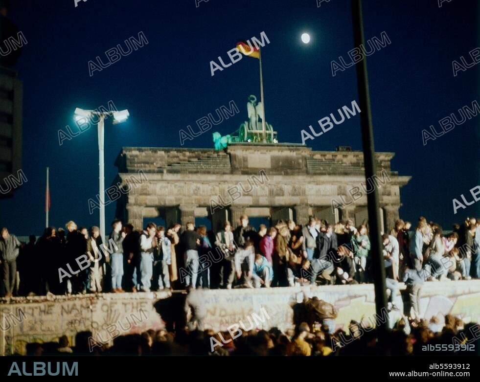 Berlin, November 1989. (Nach Öffnung der DDR-Grenzen zum Westen, 9.11.1989). Berliner aus beiden Teilen der Stadt besetzen die Mauer vor dem Brandenburger Tor. Nachtaufnahme.