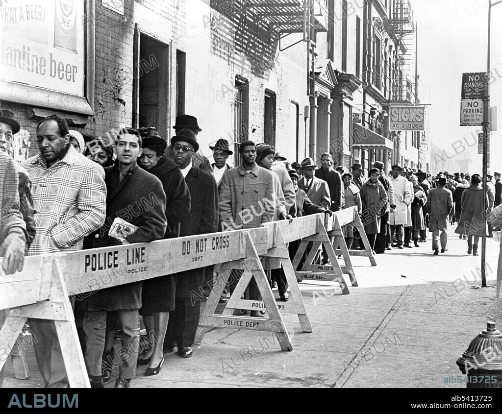 Crowds outside of Unity funeral home waiting on line to view Malcolm  X Harlem, New York City. Malcolm X (1925 - 1965) was an African-American Muslim minister and human rights activist. Detractors accused him of preaching racism, black supremacy, antisemitism, and violence. He has been called one of the greatest and most influential African- Americans in history. He was assassinated on February 21, 1965. World Telegram & Sun photo by Orlando Fernandez, 1965.