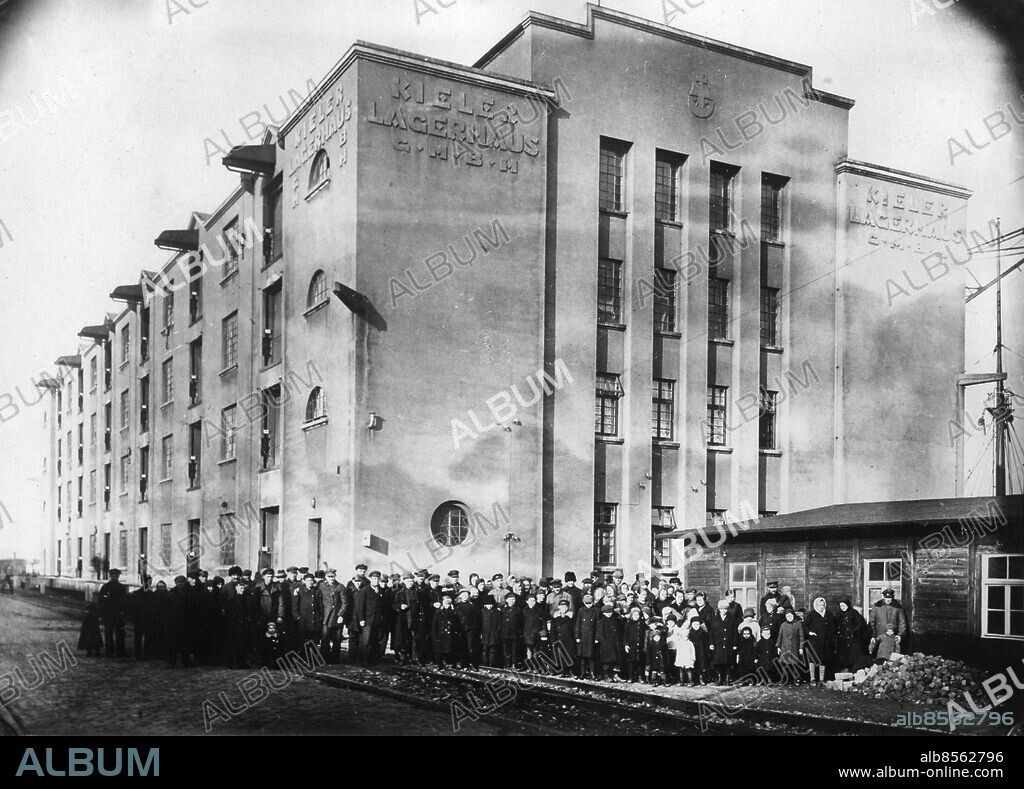 Orig. bildtext... 400 DEUTSCHRUSSISCHE AUSWANDERER IN KIEL EINGETROFFEN. In Kiel trafen mit dem russischen Dampfer "Felix Dscherschinski" gegen 400 deutschrussische Auswanderer, die sich wegen der für sie unerträglich gewordenenVerhältnisse in Kanada Eine neue Existenz gründen wollen. Sie geben an, dass ihr Reisegeld von der russischen Regierung eingezogen wurde. Da sich vällig mittellos sind, werden sie vom der Stadt Kiel unterhalten. U.B.z. die deutschrussischen Auswanderer vor dem Kieler Lagerhaus, wo sie untergebracht sind. 7.11.29 Anm. Utvandring Emigration Tyskryska utvandrare Foto: Keystone View Co / Text & Bilder Mapp: Emigranter från Ryssland 32a sites: SOVJETUNIONEN*;TYSKLAND;KIEL.