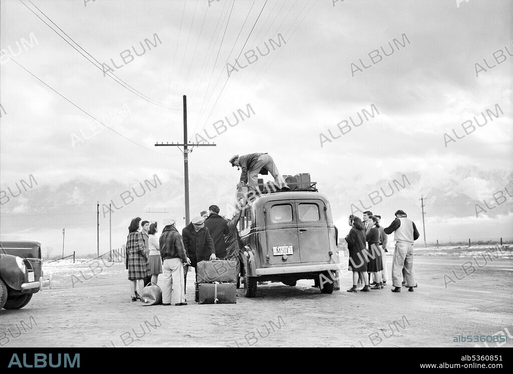 Man loading Bus with Luggage while Group of Japanese-American wait to leave Manzanar for Relocation, Manzanar Relocation Center, California, USA, Ansel Adams, Manzanar War Relocation Center Collection, 1943.