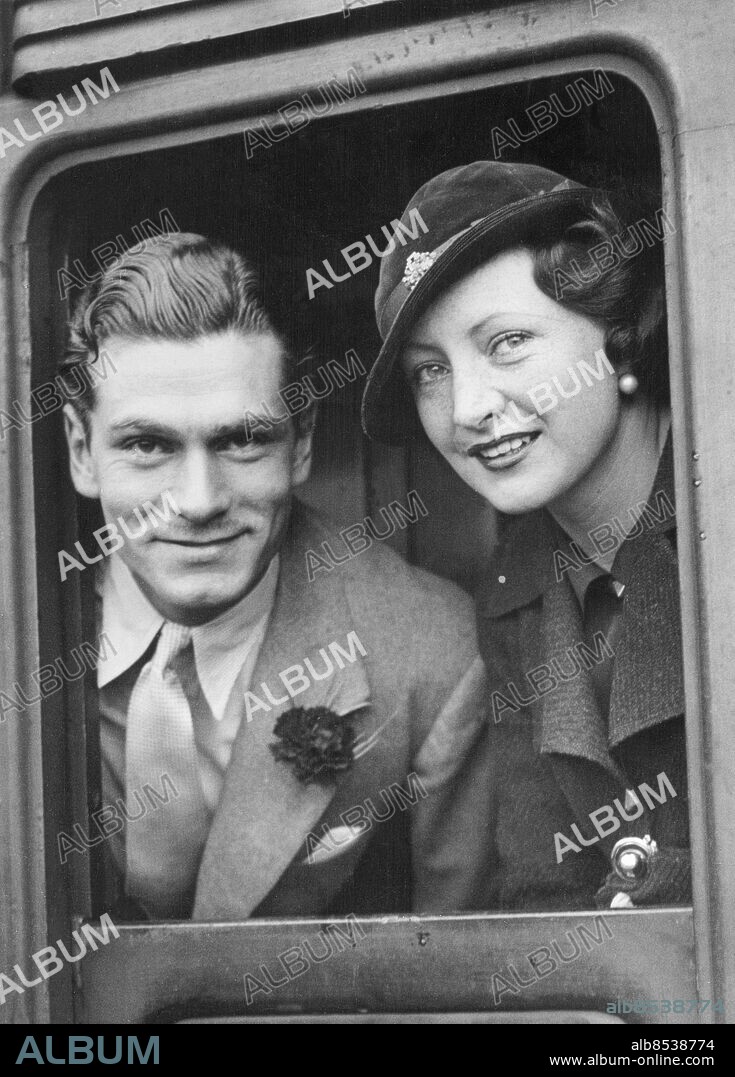 Orig. bildtext... GRETA GARBO'S NEW LEADING MAN LEAVES FOR HOLLYWOOD 15.7.33. Mr. Laurence Olivier, who is to be Greta Garbo's new leading man, left London for Southampton this morning, enroute for Hollywood. He is to appear with Greta Garbo in Queen Christina, the first Garbo film since her Swedish holiday. O.P.s. Mr. Laurence Olivier at Waterloo this morning prior to his departure. With him is his wife. Jill Esmond Orig. bildtext... GRETA GARBOS LEADING MAN i Drottning Kristina-filmen, mr. Laurence Olivier, lämnade häromdagen London för att bege sig till Hollywood. Mr. Olivier med fru vid avresan. Anm. L Olivier, 1907-1989, engelsk skådespelare och regissör. J Esmond, 1908-1990, engelsk skådespelerska, gift med L Olivier 1930-1940. Avresor Örhängen Broscher Nejlika i knapphålet Resenärer CD508 persons: LAURENCE OLIVIER;JILL ESMOND sites: STORBRITANNIEN;LONDON.