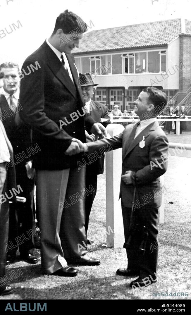 Extremes Meet - At The Races Ewart Potgieter, the giant South African heavyweight boxer who has just arrived in England, shaking hands with Sir Gordon Richards, formerly England's champion jockey and now a trainer when they met at the Brighton race meeting. Potgieter stands 7 feet 2 inches in height. August 04, 1955.