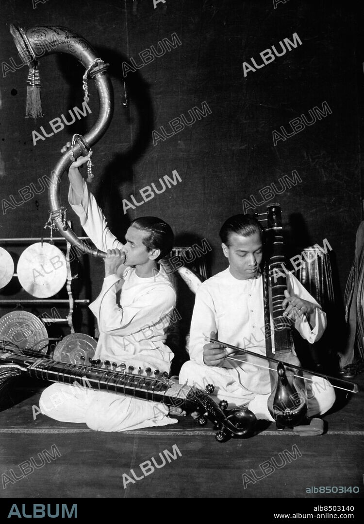 Orig. bildtext... INDISCHE MUSIK UND TÄNZE IN BERLIN. Im Theater des Westens findet jetzt das Gastspiel Brahmanisch-Indischer Tänzer statt, die unter Leitung des berühmten Tänzers Uday Shan-Kar den Berlinern ihre grosse Kunst vorführen. 56 original indische Musikinstrumente werden vom Orchester zur Begleitung der Tänze, Dramen und Legenden benutzt. Bild zeigt: Zwei Mitglieder des Orchesters mit ihren eigentümlichen Instrumenten bei der Generalprobe. Anm. Lurar CD602 sites: BERLIN;INDIEN*;TYSKLAND.