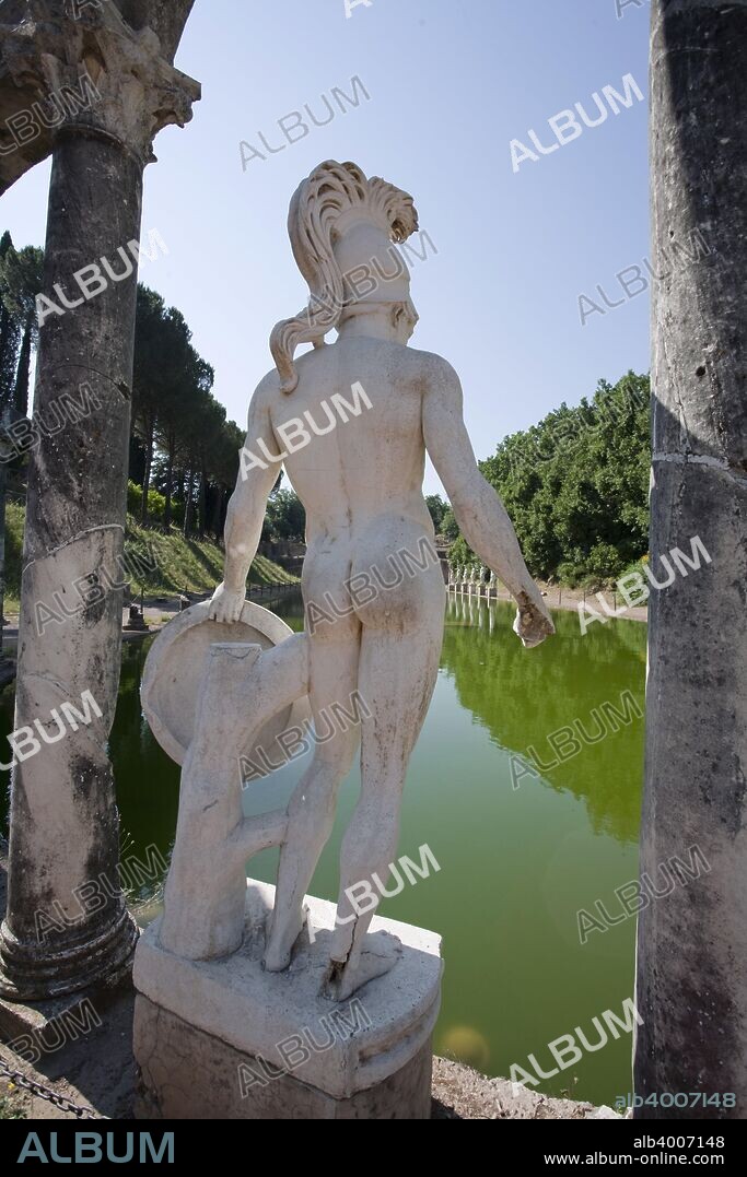 Statue of Ares/Hermes at the northern end of the Canopus, Hadrian's Villa, Tivoli, Italy. Hadrian's Villa was the luxurious retreat of Emperor Hadrian in Tibur (modern Tivoli) and was one of the most magnificent villas in the ancient world. It was built in the 2nd century AD as a home for the emperor and his court. During the later years of his reign, he actually governed the empire from the villa. The villa shows echoes of many different architectural orders, mostly Greek and Egyptian. The large Canopus pool (119 x 18 metres) was named after the canal that linked Alexandria with Canopus on the Nile delta. One of the statues that embellish the mixed architecture at the end of the semicircular Euripus at the northern end of the pool, represents a young warrior wearing a tall helmet, the so-called 'Ares', actually Hermes, recognized by the caduceus, a typical attribute of the god, traces of which are apparent on his right arm. The sculpture is a Roman copy of a Classical Greek original statue.