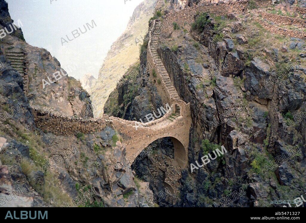 The celebrated Shahara Bridge in Yemen was built across a 300-metre deep gorge in 1620, ostensibly to repel Turkish invasions. Shaharah is a fortified village high in the Yemeni Sarawat Mountains about six hours drive north of Sana'a. Fortified mountain villages are common in Yemen, but Shaharah is the most inaccessible. Incredibly inaccessible, Shaharah has been a thorn in the side of any invading army and a bolthole for retreating imams for centuries. It wasn’t until the civil war of the ’60s that the village was finally conquered through the use of air power. In addition to its defensive fame the village has a long tradition of learning (dating back to the time of the Zaydi dynasty in the 9th century). Its scholars were known throughout south Arabia. The village lies at 2600m and overlooks mountainous bulging swells to the south and shimmering hot plains to the north. The climb up from these plains to the village takes you through some of the most impressive scenery in the country.