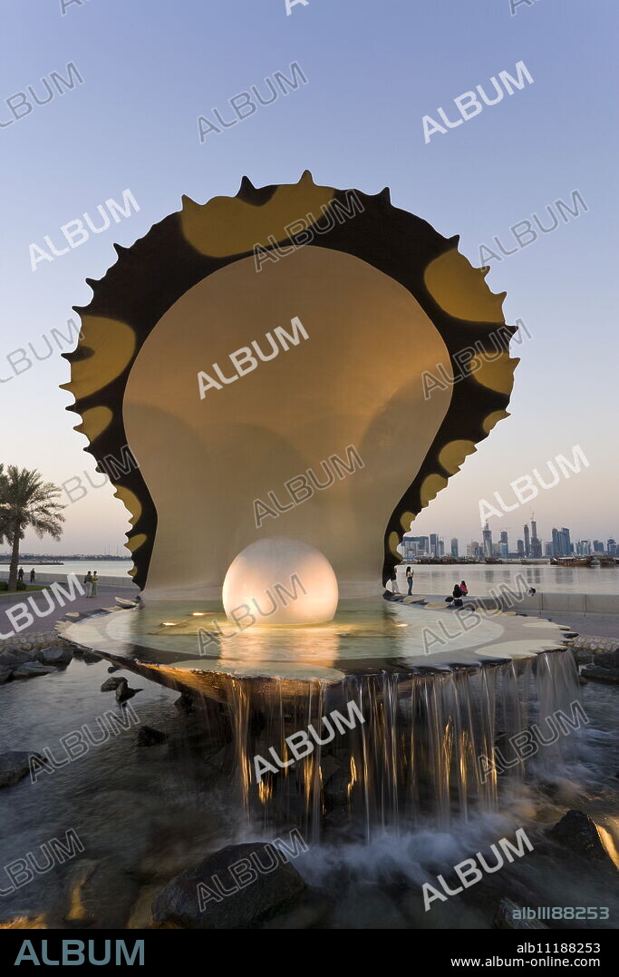 Pearl Monument on the Corniche of Doha Bay with the central business district of the West Bay on the horizon, Doha, Qatar, Middle East.