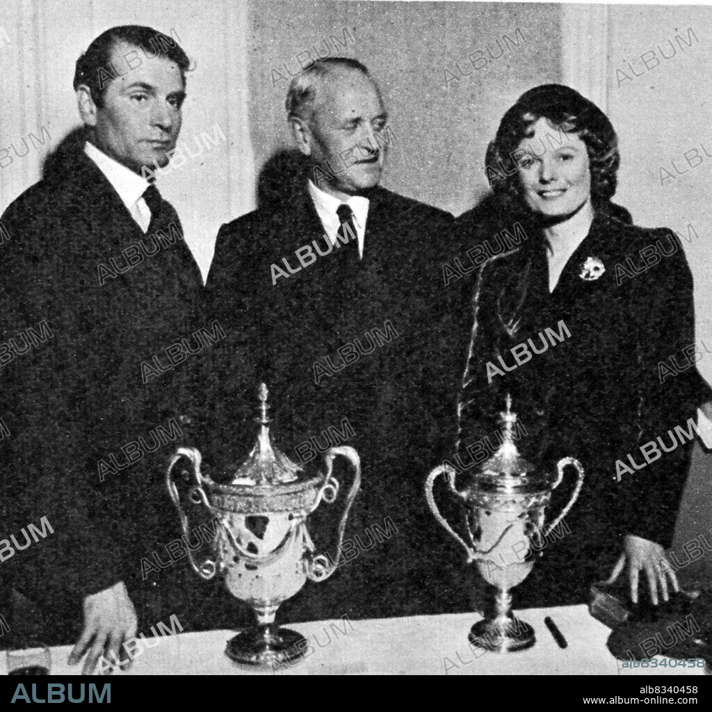 Laurence Kerr Olivier and Anna Neagle at the Picturegoer 1949 Film Trophy Awards. Laurence Kerr Olivier, Baron Olivier, OM (22 May 1907 - 11 July 1989) was an English actor and director who, along with his contemporaries Ralph Richardson and John Gielgud, was one of a trio of male actors who dominated the British stage of the mid-20th century. He also worked in films throughout his career, playing more than 50 cinema roles. Late in his career, he had considerable success in television roles. Dame Florence Marjorie Wilcox DBE (nee Robertson; 20 October 1904 - 3 June 1986), known professionally as Anna Neagle, was an English stage and film actress, singer and dancer.