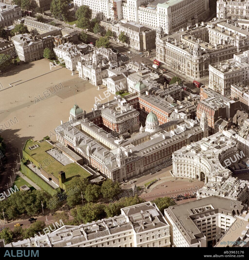 Admiralty Arch, Whitehall and Horse Guards Parade, Westminster, London, 2002. Admiralty Arch marks the end of The Mall. It was built in 1910 as part of the memorial scheme to Queen Victoria. It has three main arches, the central one only being used for ceremonial purposes. Looking down Whitehall it is possible to see Horse Guards Parade, where the Trooping of the Colour takes place. Past this is the group of houses that make up Downing Street.