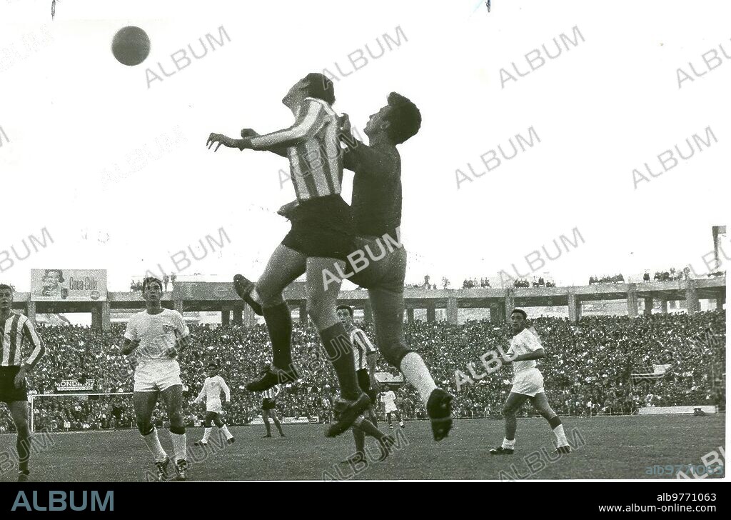 Sevilla, 1; Betis, 2 (diciembre de 1961).- El bético Areta III intenta rematar ante el portero sevillista Mut. En la foto aparece también Marcelo Campanal.