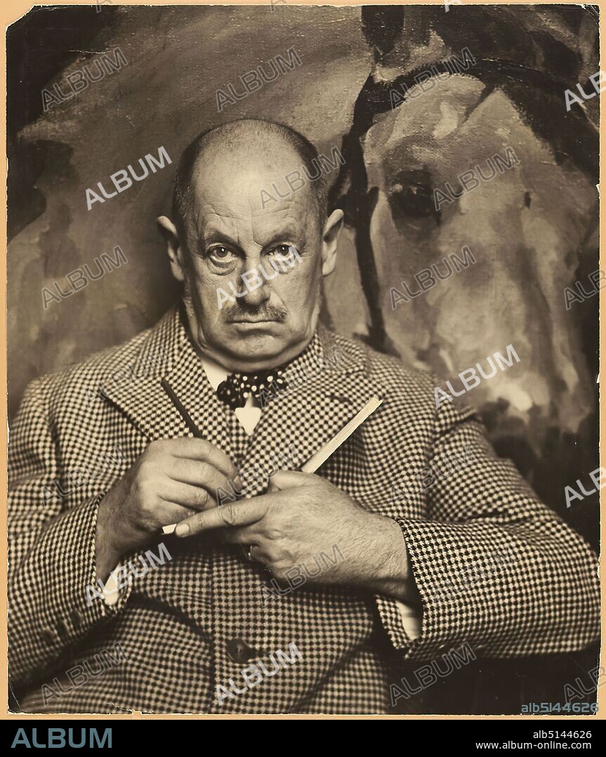 Hugo Erfurth, Max Feldbauer, Staatliche Landesbildstelle Hamburg, collection on the history of photography, silver gelatin paper, black and white positive process, image size: height: 67.7 cm; width: 56.5 cm, label: cardboard verso top left: in typescript: Hugo Erfurth /Max Feldbauer, handwritten with black felt-tip pen, supplemented: c. 1920; Hugo Erfurth, Dresden/Cologne, Max Feldbauer, c. 1920, stamp: cardboard verso and center: handwritten in lead supplemented: cabinet 14/15, upper drawer, portrait photography, portrait, artist, painting, horse, book, At the beginning of the 20th century, Hugo Erfurth is one of the most famous professional photographers in Germany, along with Rudolph Dührkoop and Nicola Perscheid. After completing an apprenticeship as a photographer, he opened his own studio in Dresden at the age of only 22. Soon Erfurth orientated himself towards the up-and-coming pictorialist photography, participated in numerous amateur photographic exhibitions from 1894 onwards and managed to make a name for himself both as an artistically ennobled amateur and successful professional photographer. Portraits are central to his work, which he began taking in 1906 in his new studio, a classicist palace, in a stylishly elegant ambience, appealing to the wealthy bourgeoisie. He also produced numerous portraits of famous personalities, including Käthe Kollwitz, Otto Dix and Joachim Ringelnatz. While his studies around 1905 still show full-length figures depicted in an atmospheric way, from the 1920s onward the focus is on the face, which is photographed against a simple monochrome background. Here, his pictorial approach corresponds to the portrait of classical modernism, whereby the technique of oil printing emphasizes the softness and materiality of the pigments and at the same time places the portraits in the art-photographic tradition. Erfurth is a co-founder of the Gesellschaft Deutscher Lichtbildner (1919), teaches at the Leipzig Academy and moves from Dre.