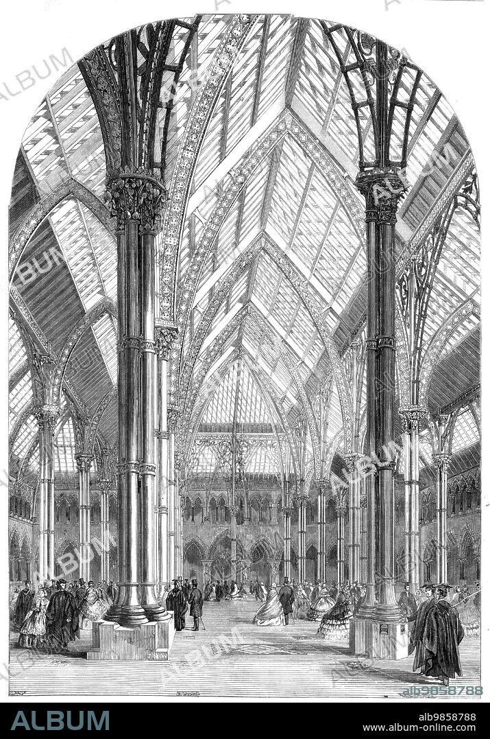 The Central Court and Arcades of the Oxford University Museum, 1860. Building designed by Thomas Newenham Deane and Benjamin Woodward. 'The centre of the edifice, which is intended to contain the various collections, consists of a spacious quadrangle, 112 feet square, which is covered by a glass roof, supported on cast-iron columns, itself a novel idea and somewhat doubtful experiment in structural arrangement in Gothic architecture. The ornamental portion of the roof is in wrought iron, and was executed by Mr. Skidmore, of Coventry. In the spandrils it takes the shape of interwoven branches, with leaf, and flower, and fruit of lime, chestnut, sycamore, walnut, palm, and other trees or shrubs of native or of exotic growth; and in various parts of the lesser decoration, in the capitals, and nestled in the trefoils of the girders, are leaves of elm, briar, water-lily, passion-flower, holly, and other plants, effectively wrought...The material of the shafts has been selected from various quarries of British rock, those in the lower arcade on the west side illustrating the granitic series, on the east the metamorphic, and on the north the calcareous, chiefly from Ireland; whilst on the south side the marbles of England are represented'. From "Illustrated London News", 1860.