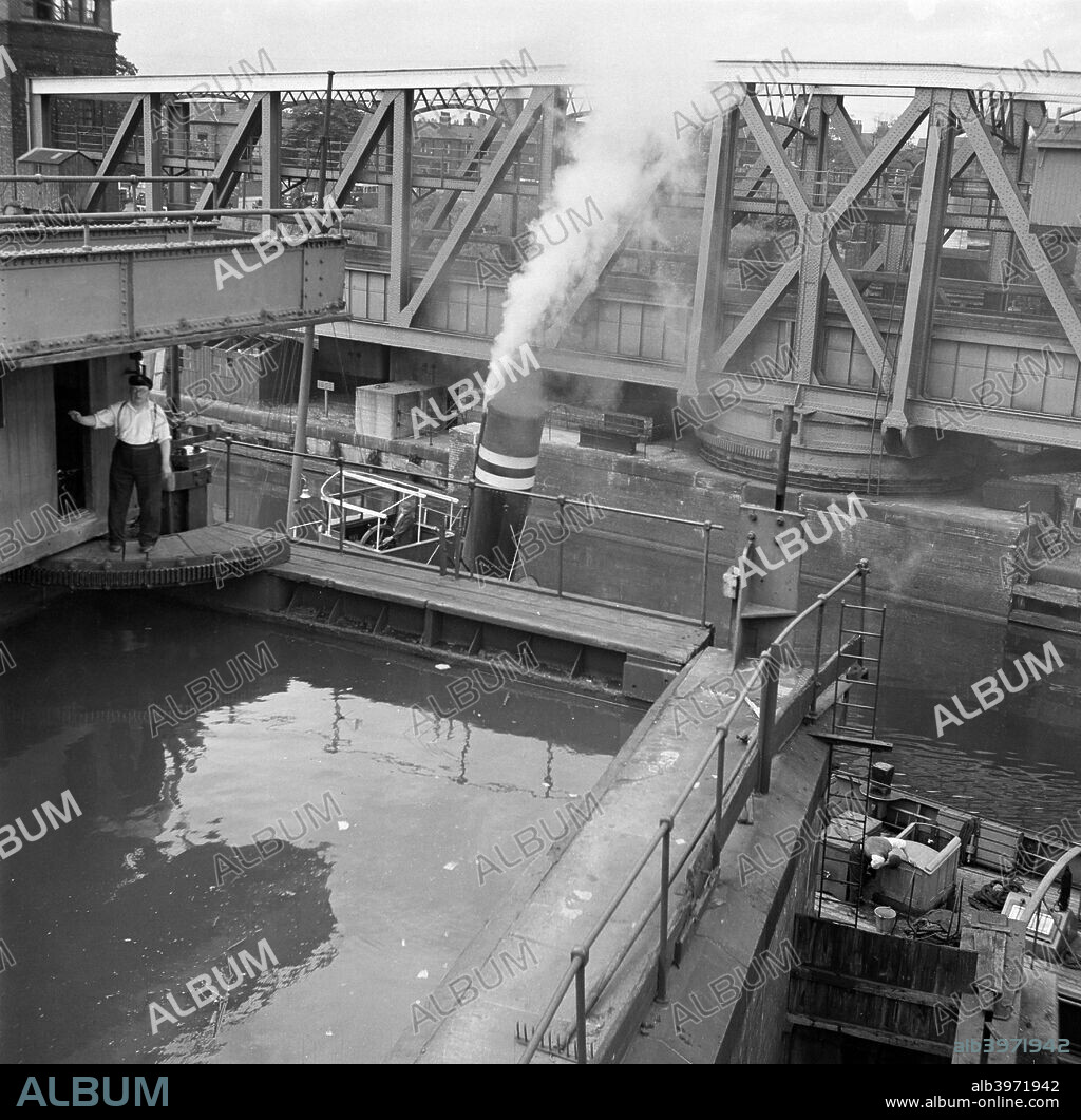 Manchester Ship Canal and Barton Aqueduct, Eccles, Greater Manchester, 1945. The Barton Aqueduct opened to allow a vessel to pass on the Manchester Ship Canal. Designed by Sir Edward Leader Williams, the Barton Aqueduct is a swing bridge that carries the Bridgewater Canal over the Manchester Ship Canal. It became operational in 1893.