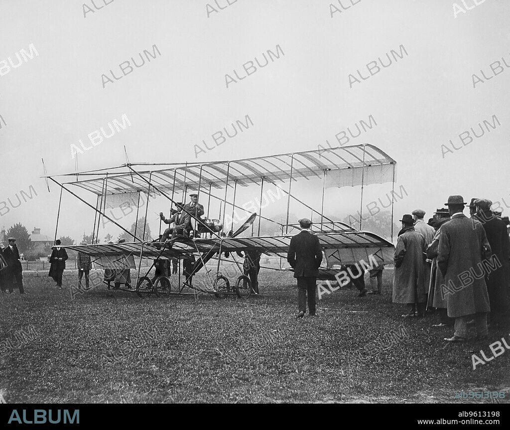 Farman biplane, Bournemouth, Dorset, 1910. A group of men watching as two men take their seats in the aircraft. The pilot has been identified as Claude Grahame-White, pioneer of aerial reconnaissance. From the EGPN Collection held by the English Heritage Archive.