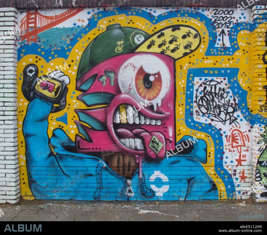 Pintura estilo cómic de torso con cara de monstruo con gorra, todo muy colorido, graffiti mural, calle Selva de Mar, barrio Poblenou, Barcelona en 2016.