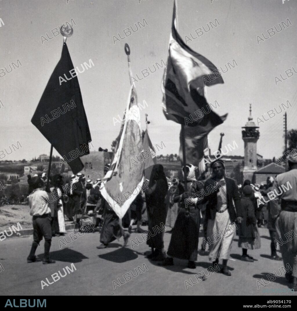 Nablus flag arriving for the Nabi Musa festival, 1936. Nabi Musa is the name of a site in the Judean desert that popular Palestinian folklore associates with Moses. It is also the name of a seven-day long religious festival that was celebrated annually by Palestinian Muslims. It was considered 'the most important Muslim pilgrimage in Palestine,' and centered around a collective pilgrimage from Jerusalem to what was understood to be the Tomb of Moses, near Jericho.