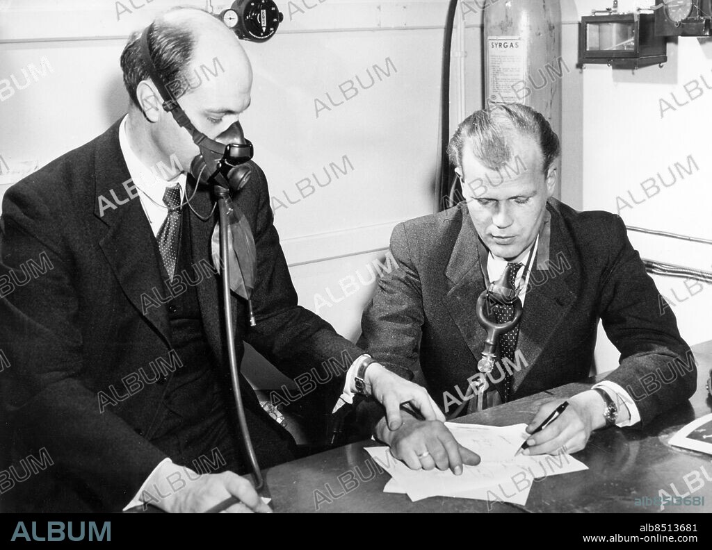 STOCKHOLM 1952-04-09.. Pressbesök på GCI:s tryckkammare varvid en grupp segelflygare fick tjänstgöra som försöksobjekt. Här kontrollerar Dr Åkerblad Olle Perrers puls på 6500 meters höjd utan syrgasmask.. Foto: Owe Sjöblom / AB Text & Bilder / SVT / Kod: 5600. Mapp: GCI-gymnaster (Här även invigningen av GCI -45) I 20a. Syrgasmasker Masker GCI.