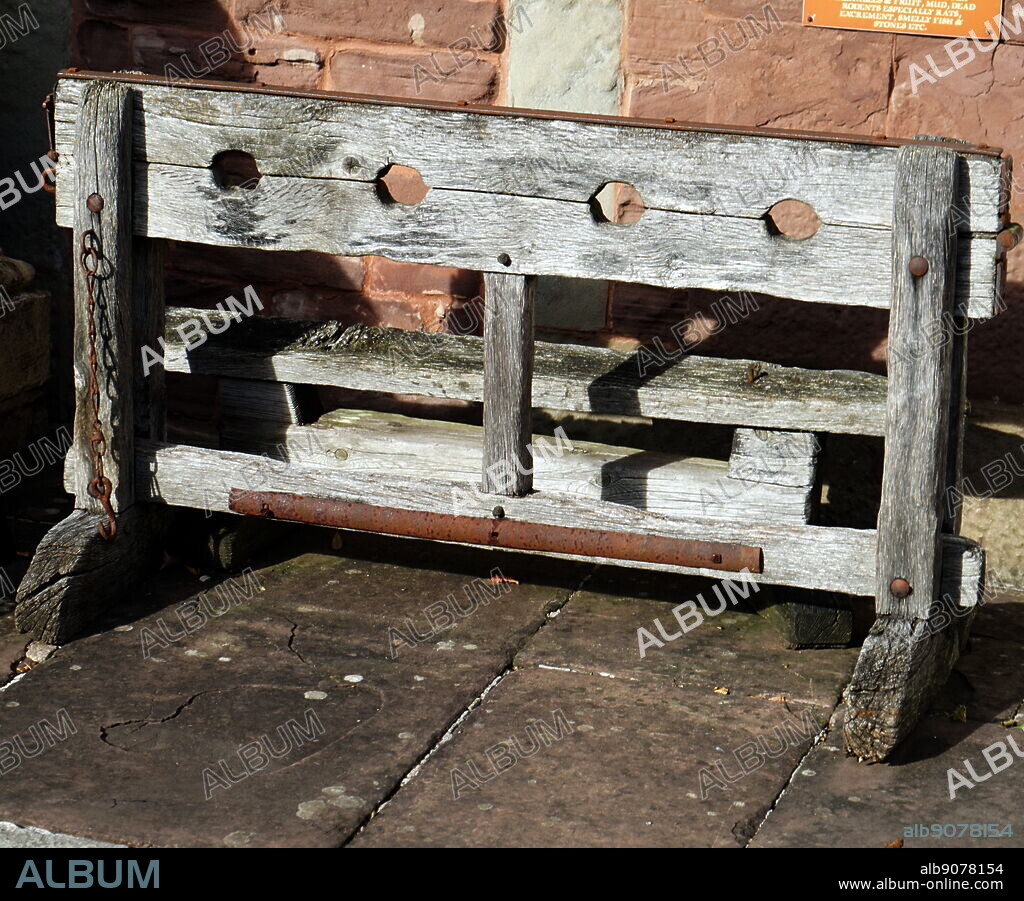 A replica of medieval wooden stocks. Stocks were restraining devices used as a formal of corporal punishment and public humiliation.