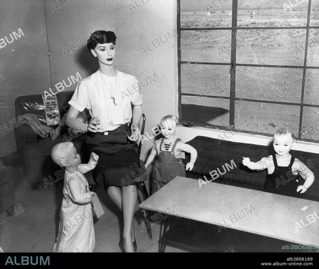 Mannequin woman and three mannequin children in living room. Operation Doorstep was a civil defense study conducted by the Federal Civil Defense Administration in conjunction with Upshot-Knothole Annie. It studied the effect of the nuclear blast on two wooden frame houses, fifty automobiles and eight bomb shelters designed for residential use. The homes in the study were constructed in such a way as to minimize the thermal effects of Annie, with an eye towards determining if, in the absence of fire, the basement of the closer home (3,500 feet from the hypocenter) might shelter its occupants, while the second (at 7,500 feet) could remain standing. Both homes performed as expected under the conditions of their construction. Upshot-Knothole Annie was a nuclear weapons test conducted by the United States as part of Operation Upshot-Knothole. It took place at the Nevada Test Site on March 17, 1953, and was nationally televised. The live TV coverage was captured at the studio, presumably using at-the-time new magnetic tape sound technology, so it is a rare record of the sound an actual atomic bomb makes.
